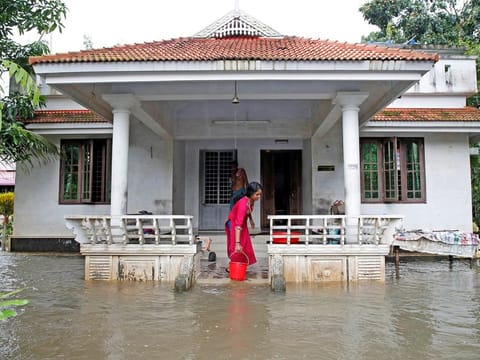 A woman clears out the water from her flooded house at Paravur on the outskirts of Kochi, in the southern state of Kerala, India August 11, 2019.