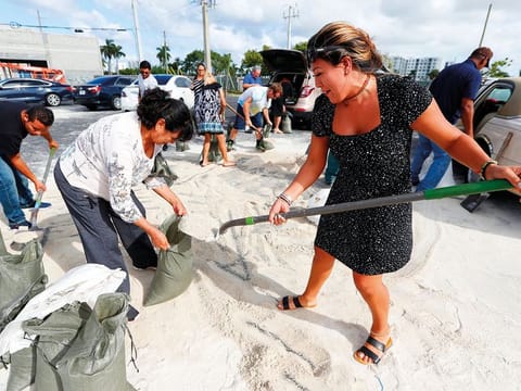 Georgia Bernard and Ana Perez fill sandbags in preparation for Hurricane Dorian on Friday in Hallandale Beach, Florida. The town allowed filling up sandbags until they ran out.