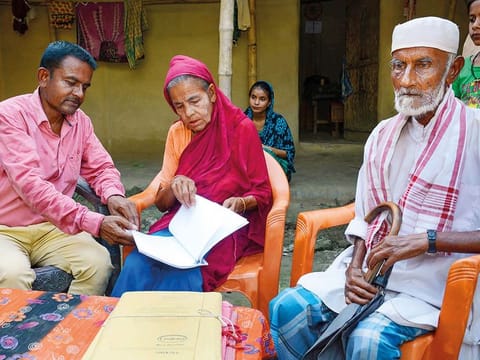 File: Khaibar Ali, left, along with his father Jahur Ali and mother Sarifa Bebi, check the names in the published final list of the National Register of Citizens (NRC), at Gorbhetar village in Baska district of Assam.