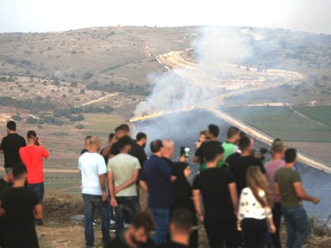 Maroun Al-Ras: Lebanese journalists and villagers watch as Israeli army shells cause fires on the southern Lebanese border village of Maroun Al-Ras, Lebanon.