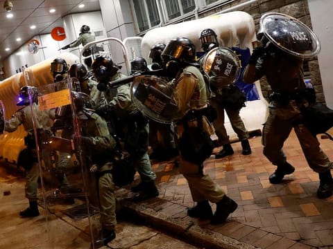 Riot police hold their shields outside Mong Kok police station, next to Prince Edward MTR station in Hong Kong, China.