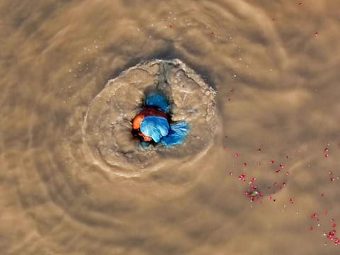Allahabad: A woman takes a dip in the muddy water of River Ganga, in Allahabad, Wednesday, Sept 26, 2018.