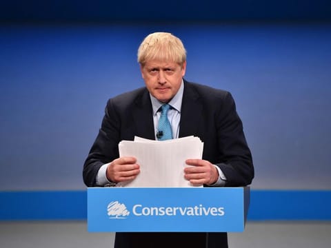 Britain's Prime Minister Boris Johnson shuffles his papers as he delivers his keynote speech to delegates on the final day of the annual Conservative Party conference at the Manchester Central convention complex, in Manchester, north-west England on October 2, 2019