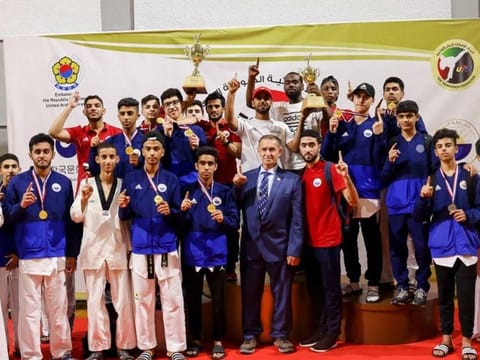 Abdullah Hatim celebrates with the winning Taekwondo team of Sharjah Club at the UAE_Korea Taekwondo Championship. Grand Master Zeyad Hammad Abu Zahieh is also present.