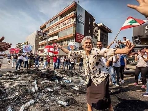 This elderly Lebanese woman is seen enjoying herself at a protest.