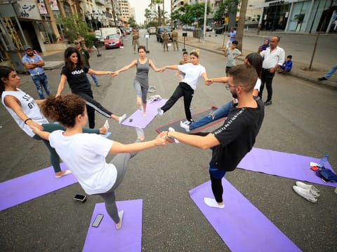People practice yoga on a street as security forces stand nearby during ongoing anti-government protests in Sidon, Lebanon October 27, 2019.