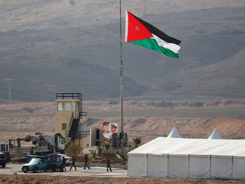 A Jordanian national flag is lifted near a tent at the "Island of Peace" in an area known as Naharayim in Hebrew and Baquora in Arabic, on the Jordanian side of the border with Israel, as seen from the Israeli side November 10, 2019