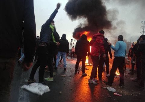 Iranian protesters gather around a fire during a demonstration against an increase in gasoline prices in the capital Tehran, on November 16, 2019