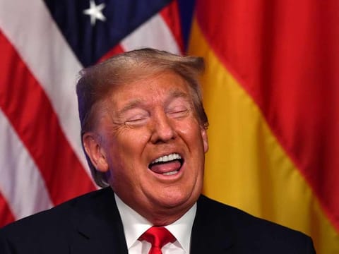 US President Donald Trump gestures during a bilateral meeting with German Chancellor Angela Merkel on the sidelines of the NATO summit at the Grove hotel in Watford, northeast of London on December 4, 2019.