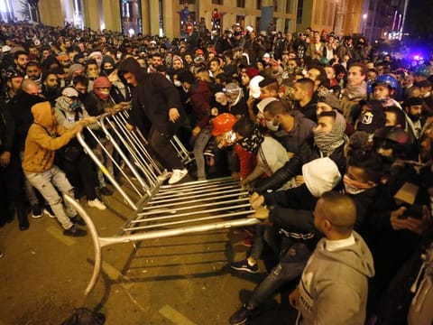 Anti-government protesters remove the fences that was divided between them and the riot police, during a protest near the parliament square, in downtown Beirut, Lebanon, Sunday, Dec. 15, 2019.
