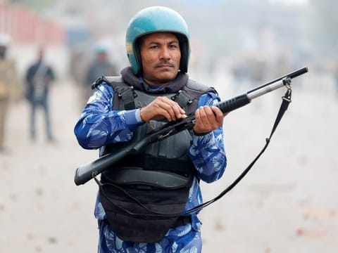 A riot police officer loads a rifle during a protest against a new citizenship law in Seelampur, area of Delhi, India December 17, 2019. REUTERS/Adnan Abidi
