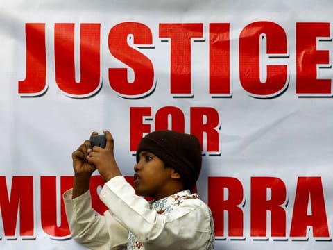 A boy films the supporters of Pervez Musharraf, after a Pakistani court sentenced the former military ruler to death on charges of high treason and subverting the constitution, during a protest in Karachi on December 20, 2019.