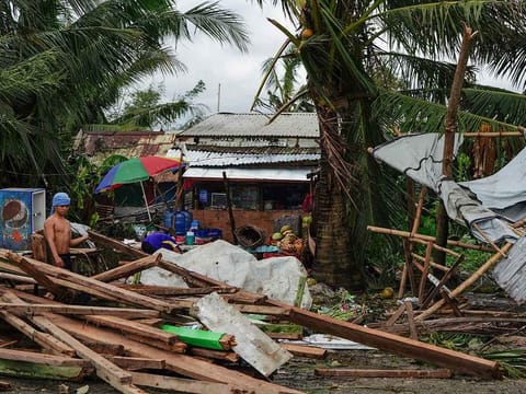 A resident looks at a house damaged at the height of Typhoon Phanfone in Tacloban, Leyte province in the central Philippines on December 25, 2019