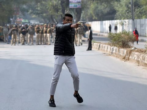 A man brandishes a gun during a protest against a new citizenship law outside the Jamia Millia Islamia university in New Delhi, on January 30, 2020.