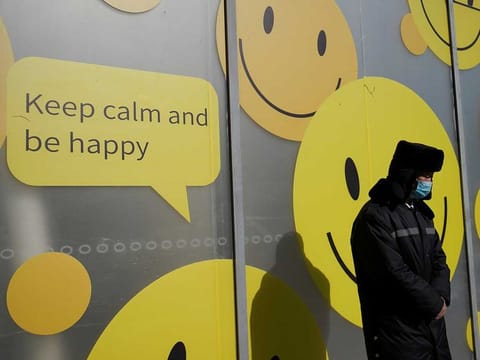 A security personnel wearing a face mask stands by a shopping mall in Beijing, China.