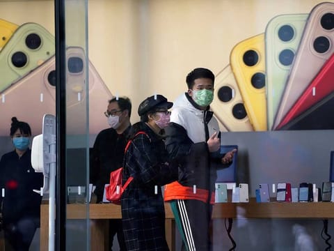 People wearing protective masks are seen in an Apple Store, as China is hit by an outbreak of the new coronavirus, in Shanghai, China.
