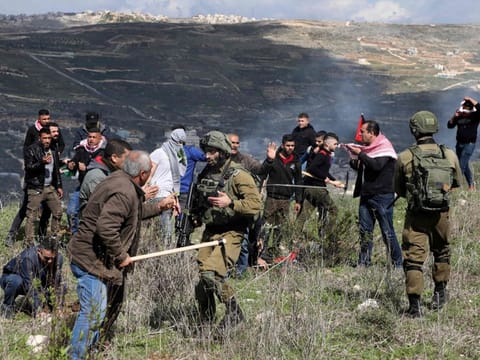 Israeli soldiers block Palestinian protesters from planting olive trees in a field in Asira Al Qibliya town, south of Nablus, on February 21, 2020, following a weekly demonstration.