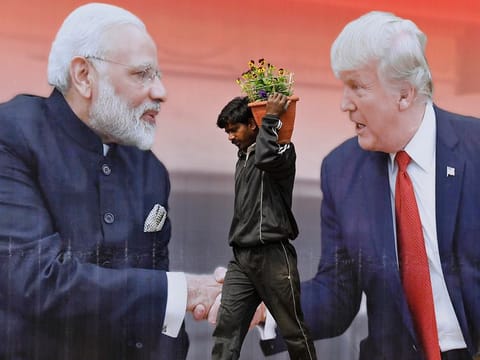 File picture: An Indian worker walks carrying flowers to plant passes a billboard featuring US President Donald Trump and Indian Prime Minister Narendra Modi, in Agra, India, Sunday, February 23, 2020.