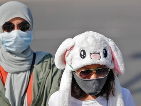 Tourists wearing protective masks walk in a street following an outbreak of the coronavirus disease, in New Delhi on March 9.