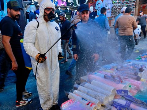 A civil defense worker wearing a protective suit sprays disinfectant as a precaution against the new coronavirus, in the main market, Baghdad, Iraq, Tuesday, March 10, 2020. For most people, the new coronavirus causes only mild or moderate symptoms, such as fever and cough. For some, especially older adults and people with existing health problems, it can cause more severe illness, including pneumonia.