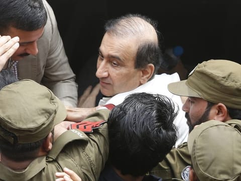 Pakistani police officers escort Mir Shakilur Rahman, owner of Jang Group of Newspapers, to an anti-graft court in Lahore on March 13.