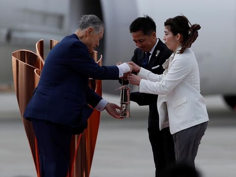 Tokyo 2020 Olympics President Yoshiro Mori receives the Olympic Flame from three-time Olympic gold medalists Tadahiro Nomura and Saori Yoshidabe who transported it from Greece to Japan, at Japan Air Self-Defense Force Matsushima Base in Higashi-Matsuhsima, Miyagi prefecture, northern Japan March 20, 2020.