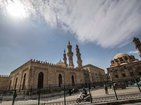 A few people walk in the vicinity of the closed Al-Azhar mosque in Egypt's capital Cairo on March 20, 2020, after the country's Muslim religious authorities decided to put the Friday prayers on hold, in order to avoid gatherings and the spread of the novel coronavirus COVID-19 disease. / AFP / Khaled DESOUKI