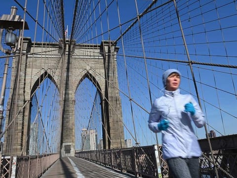A solitary jogger crosses the Brooklyn Bridge on March 18, 2020 in New York City.