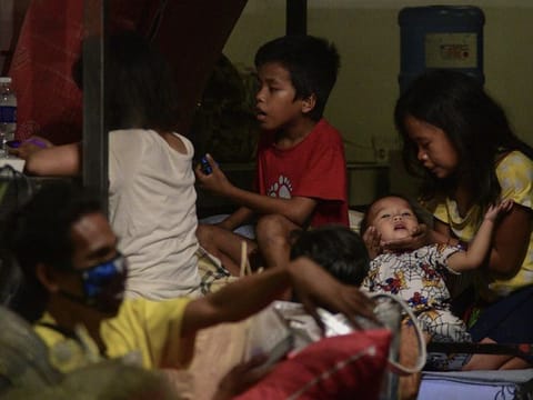 Homeless children sit inside a restaurant in Quezon City in Manila after the shop converted parts of its premises into a shelter for the homeless amid the island-wide lockdown aimed at curbing the spread of the COVID-19 coronavirus outbreak on March 21, 2020.