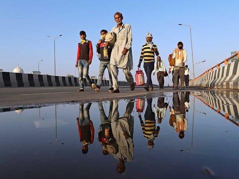 Migrant workers and their families walk along a road during a lockdown imposed due to the coronavirus outbreak, in New Delhi, India, on March 28, 2020.