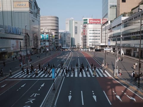 Pedestrian cross a road in the Shinjuku district of Tokyo, Japan, on Saturday, April 4, 2020. With Prime Minister Shinzo Abe’s government stuck on the brink of declaring a state of emergency that might lead to a lockdown, Japan’s restaurant, bar and chain stores are taking matters into their own hands by voluntarily shuttering hundreds of stores to help curb the spread of the coronavirus.