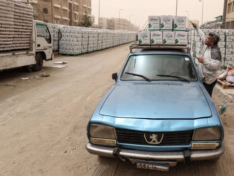 An Egyptian man loads his car with cartons with foodstuffs outside a centre of non-governmental organisation Egyptian Food Bank on April 5 as the charity distributes aid to people who lost their jobs due to the coronavirus pandemic crisis, in the Egyptian capital Cairo.