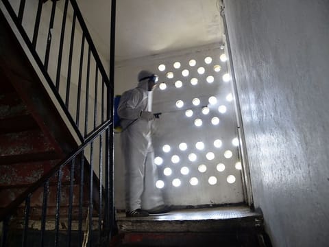 Municipal workers dressed in protective gear disinfect a building during the COVID-19 coronavirus pandemic in the Bab el-Oued district of Algeria's capital Algiers on April 9, 2020.