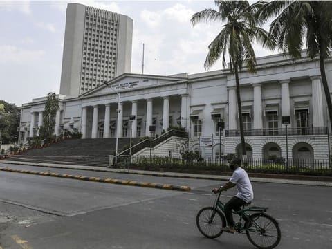 A lone cyclist passes the Reserve Bank of India headquarters during a lockdown in Mumbai