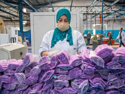 A factory worker packages disposable protective masks along a production line in Morocco's Casablanca on April 10, 2020, as the North African country increases mask production due to the COVID-19 coronavirus pandemic.