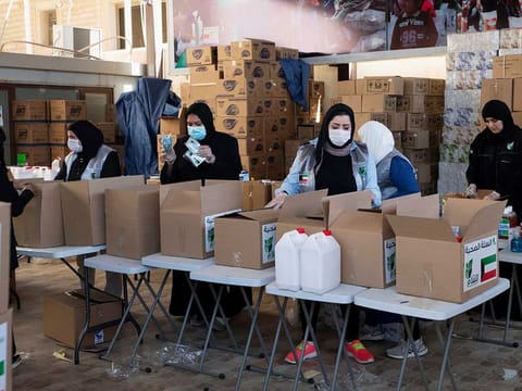 Kuwaiti volunteers wear protective masks as they fill charity boxes with essential household supplies in this file picture from Kuwait.