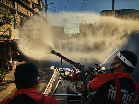 Firefighters spray disinfectant along a road in Manila, Philippines, Monday, April 6, 2020, in an effort to keep the coronavirus from spreading. Philippines President Rodrigo Duterte's lockdown of Luzon, the Philippines' largest island and home to Manila, is moving into its second month, plunging the people of San Roque, a suburb of Quezon City, even deeper into poverty as the virus continues to rage.