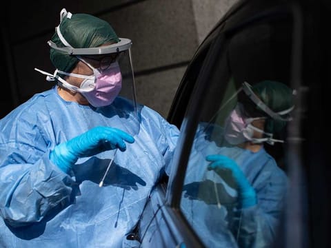 A health worker takes a sample for a PCR test for the COVID-19 coronavirus at a hospital in Coslada, Spain, Monday, April 20, 2020. The Spanish government is starting to relax its confinement measures due to the COVID-19 coronavirus outbreak, trying to re-activate the economy after a two-week freeze and allowing children under 12 years-old to venture out to the streets for brief periods from next week.