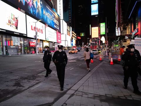 Police officers patrol New York's Times Square on foot, Wednesday night, April 29, 2020, during the coronavirus pandemic. President Donald Trump said Wednesday the federal government will not be extending its coronavirus social distancing guidelines once they expire Thursday.