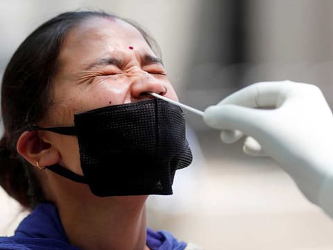 A doctor takes a swab from a woman's nose to test for the coronavirus at a mobile testing centre, during an extended nationwide lockdown to slow the spread of the disease (COVID-19), in New Delhi, India, on May 2, 2020.