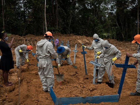 Cemetery workers place crosses over a common grave after burying five people at the Nossa Senhora Aparecida cemetery amid the new coronavirus pandemic in Manaus, Brazil, Wednesday, May 13, 2020.
