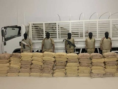 Saudi narcotics combat personnel display a drug haul seized from Al Houthi-linked agents.