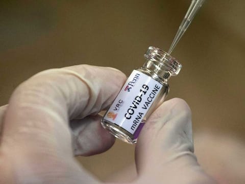 A lab technician extracts a portion of a COVID-19 vaccine candidate during testing at the Chula Vaccine Research Centre, run by Chulalongkorn University in Bangkok, Thailand, on May 25, 2020.