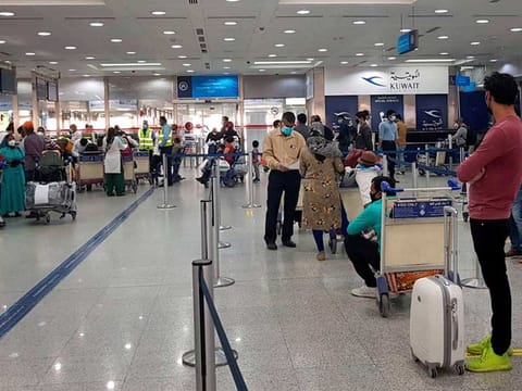 Stranded Indian nationals check-in at Kuwait International Airport (above) to travel back home as part of government's 'Vande Bharat' mission, amid ongoing coronavirus pandemic, in Kuwait on May 13. On Tuesday, May 26, the first group of illegal Indian workers in Kuwait left for home as part of a deportation plan running for 10 days.