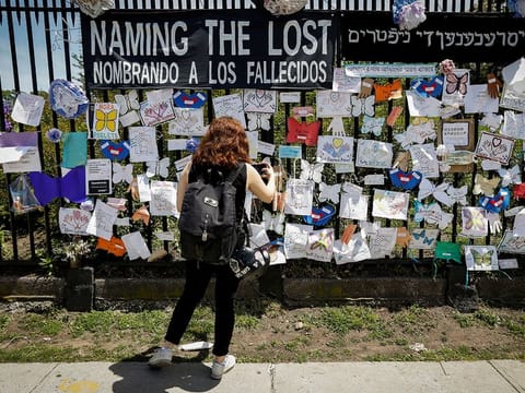 A woman photographs a memorial for those who have died from the coronavirus outside The Green-Wood Cemetery, during the outbreak of the coronavirus disease (COVID-19) in Brooklyn borough of New York, U.S., May 27, 2020.