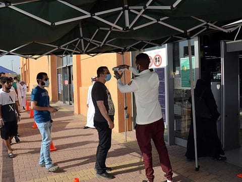 Shoppers queue up outside a mall in the Saudi city of Medina on Thursday.