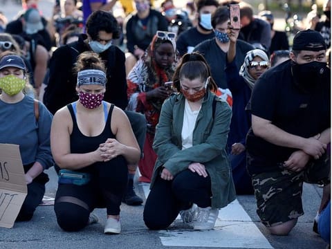 Peaceful demonstrators observe a moment of silence outside the US Bank Stadium during the fourth day of protests after the killing of George Floyd in Minneapolis