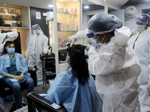 Women wearing PPE kits working at a Beauty parlour, in Kolkata on Saturday.