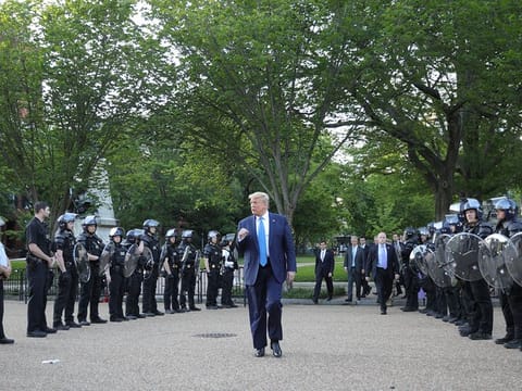 US President Donald Trump pumps his fist toward police as he walks between lines of riot police in Lafayette Park across from the White House while walking to St John's Church for a photo opportunity during ongoing protests over racial inequality in the wake of the death of George Floyd while in Minneapolis police custody, at the White House in Washington, U.S., June 1, 2020.