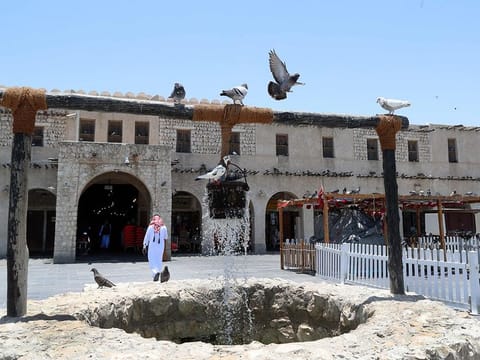 Pigeons linger around a fountain at Qatar's touristic Souq Waqif bazar in the capital Doha, on May 17, 2020, as the country begins enforcing the world's toughest penalties for failing to wear masks in public while it battles one of the world's highest coronavirus infection rates. More than 30,000 people have tested positive for COVID-19 in the tiny Gulf country, 1.1 percent of the 2.75 million population, although just 15 people have died. Violators of the new rules will face up to three years in jail and fines of as much as $55,000.